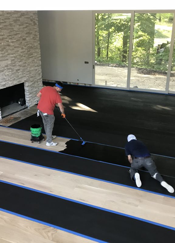 Hand-applying stain stripe by stripe during a Highland Park refinish